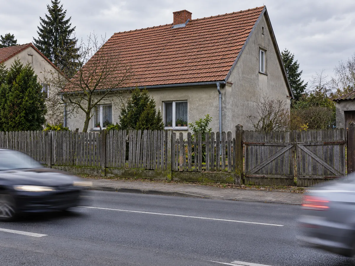 Stary drewniany płot przy ruchliwej ulicy